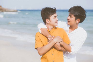 Homoseksüel portre. Genç Asyalı çift ayakta birbirlerine sarılıyorlar. 