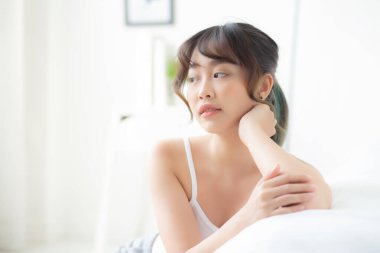 Genç Asyalı güzel bir kadının portresi sağlıklı uyanırken gülümsüyor.