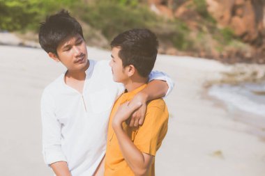 Homoseksüel portre. Genç Asyalı çift ayakta birbirlerine sarılıyorlar. 