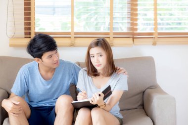 Genç ve güzel Asyalı çift not defterine bir şeyler yazıp planlıyorlar. 