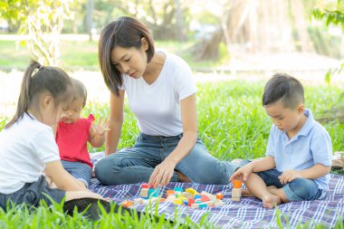 Güzel Asyalı genç anne ve kız, le için oyuncak blokları oynuyorlar.