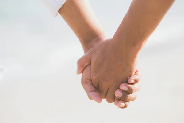 Primer plano asiático gay pareja cogida de la mano juntos en la playa ingenio —  Fotos de Stock