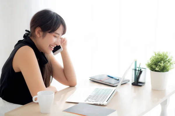 Mooie jonge freelance Aziatische vrouw glimlachend werken op laptop — Stockfoto
