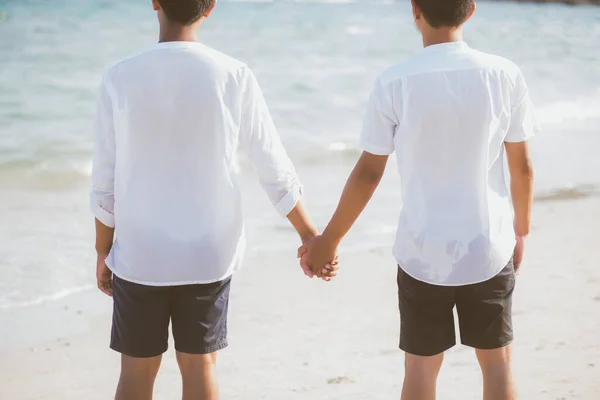 Пара азіатських геїв тримається за руки на пляжі з розслабленням — стокове фото
