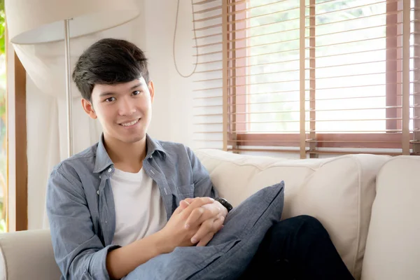 Портрет молодий красивий азіатський чоловік прив'язується розслабитися з затишним на софі — стокове фото