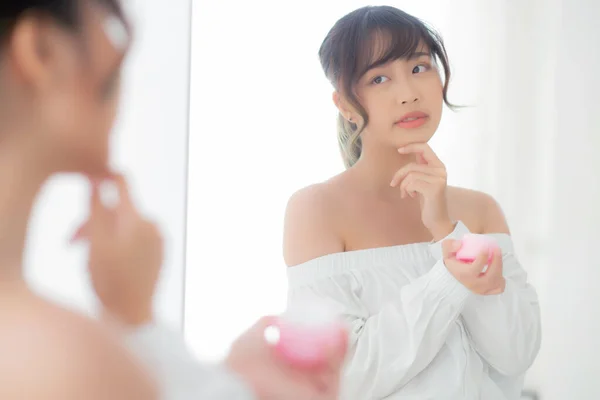 Retrato bonito jovem mulher asiática aplicando creme hidratante — Fotografia de Stock