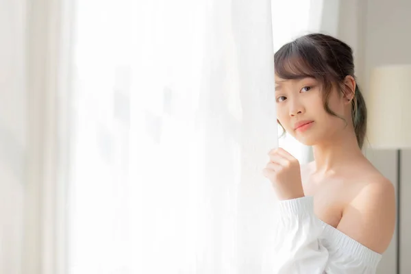 Портрет красивой молодой азиатской женщины, стоящей у окна и — стоковое фото