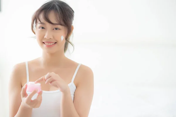 Bela jovem asiático mulher feliz aplicando creme ou loção com — Fotografia de Stock