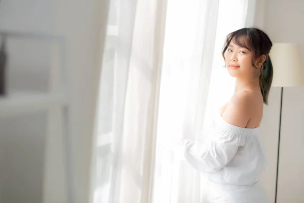 Retrato de bela jovem asiática mulher de pé a janela e — Fotografia de Stock
