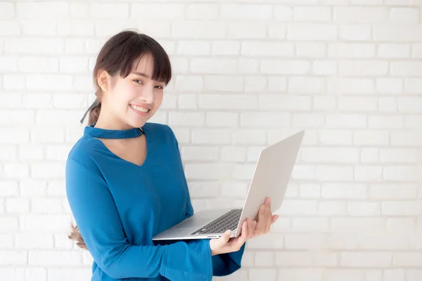Mooie portret Aziatische jonge vrouw glimlach met behulp van laptop staande — Stockfoto