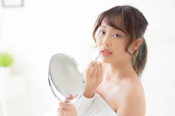 Retrato bonito jovem asiático mulher olhando espelho aplicando mak — Fotografia de Stock