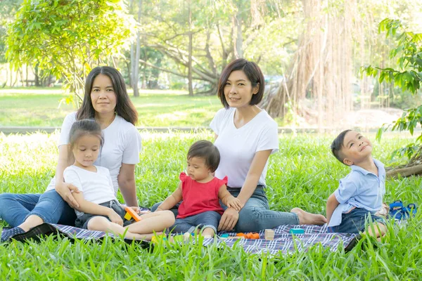 Beautiful young asian parent family portrait picnic in the park,