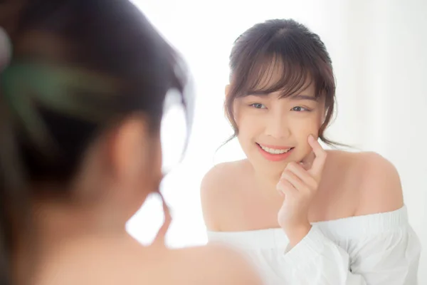 Güzel yüzlü genç Asyalı kadın mutlu gülümsüyor ve bakıyor. — Stok fotoğraf