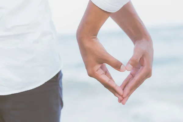 Closeup hand heart shape of young couple gay holding together on