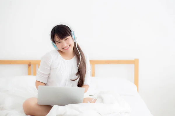 Bella giovane asiatica sdraiata in camera da letto con computer portatile calcolare — Foto Stock