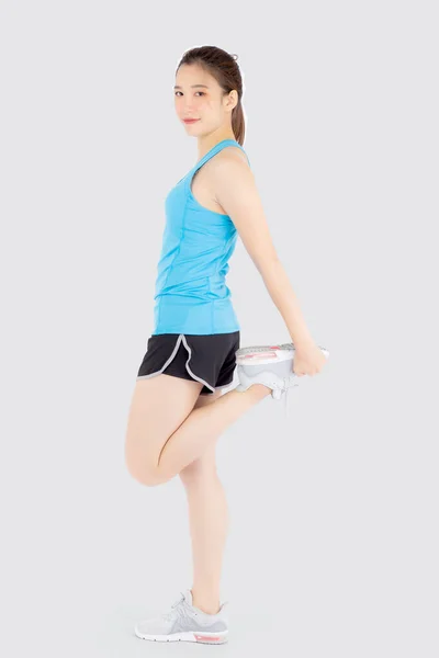 Hermosa joven asiática mujer en deporte de pie estiramiento muscular pierna —  Fotos de Stock