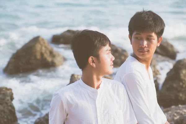Гомосексуальний портрет молодої азіатської пари, що сидить, обіймається разом на р — стокове фото