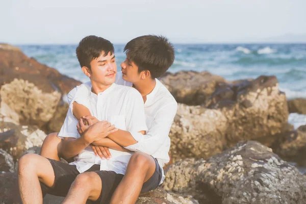 Гомосексуальний портрет молодої азіатської пари, що сидить, обіймається разом на р — стокове фото