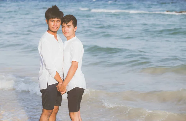 一对年轻的亚洲夫妇在海滩上站在一起 — 图库照片
