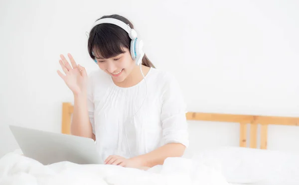 Güzel genç asya kadın dizüstü bilgisayar kullanarak yatak odasında yalan — Stok fotoğraf