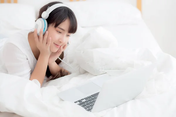 Linda jovem mulher asiática deitada no quarto usando laptop computar — Fotografia de Stock