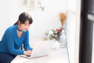 Güzel portre asya genç kadın dizüstü bilgisayar üzerinde online çalışma oturup