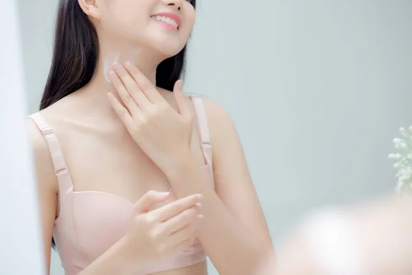 Attractive Young Asian Woman In Sports Bras Applying Moisturizer On Her  Shoulder On Beige Background High-Res Stock Photo - Getty Images