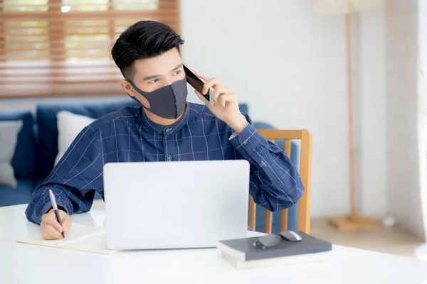 Junge Asiatische Geschäftsmann Mit Gesichtsmaske Reden Smartphone Und Arbeiten Laptop — Stockfoto