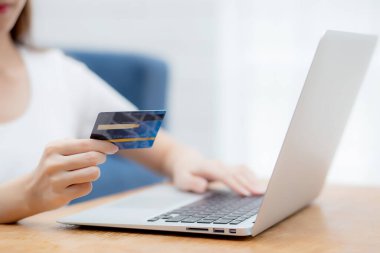 Bilgisayarla kredi kartı alışverişi yapan genç bir kadının eli, İnternet, ticaret ve e-ticaret, finans alışverişi, iş konsepti.
