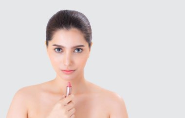 Beyaz arka planda izole edilmiş dudak rujuyla makyaj yapan genç Asyalı bir kadın, mutlu dudaklarda güzel bir kız, dudakta kadın makyajı, cilt bakımı ve kozmetik konsept..