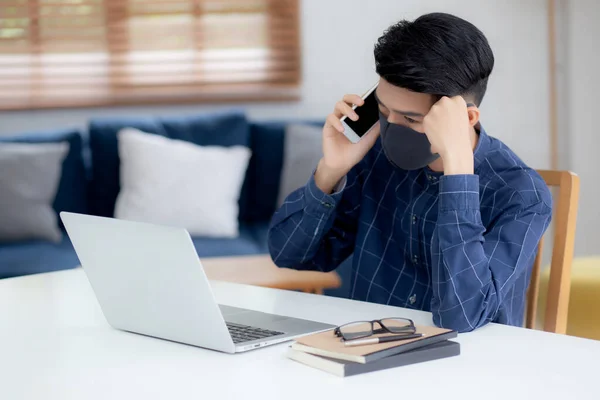 Junge Asiatische Geschäftsmann Mit Gesichtsmaske Sprechen Smartphone Und Arbeiten Laptop — Stockfoto