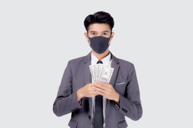 Yüz maskeli genç Asyalı işadamı para dolarını beyaz arka planda, salgın hastalıkta ve ekonomik krizde, tıbbi maske takan ve hastalık sırasında yatırım yapan işadamında izole etti..