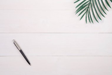 Ahşap masa üzerinde yaprak ve kalem, üst görünümü olan kompozisyon, dal ve yapraklar fotokopi alanı, doku arka planı, yeşillik tropikal, kimse, düz konsept, minimum konsept.