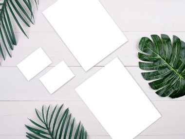 Boş kağıt kağıtlar ve isim kartı maketleri ahşap masa ve yaprak, poster ve davetiye, kartpostal ve kartvizit dekorasyonu tasarım veya markalaşma, hiç kimse, düz döşeme, üst görünüm.