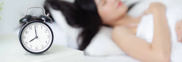 Beautiful young asian woman sleep with relax on the bed with alarm clock in the morning, girl sleep with cozy and comfort after tired, oversleep with time late, lifestyle concept, banner website.