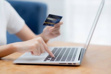 Bilgisayarla kredi kartı alışverişi yapan genç bir kadının eli, İnternet, ticaret ve e-ticaret, finans alışverişi, iş konsepti.