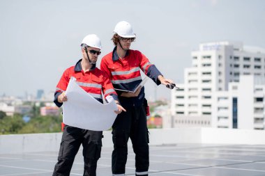 Güneş enerjisi sistemini kontrol eden iki mühendis, kurulum güneş paneli, yenilenebilir enerji ve sürdürülebilir teknoloji, temiz elektrik, sanayi ve güneş hücresi planlama projesini birlikte inceliyor..
