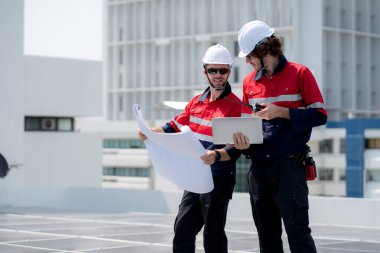 Güneş enerjisi sistemini kontrol eden iki mühendis, kurulum güneş paneli, yenilenebilir enerji ve sürdürülebilir teknoloji, temiz elektrik, sanayi ve güneş hücresi planlama projesini birlikte inceliyor..