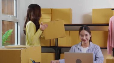 İki genç Asyalı iş kadını dizüstü bilgisayar ve belge, sevkiyat ve kargo, perakende satış ve mağaza, başlangıç veya küçük işletme, nakliye ve envanter siparişlerini kontrol ediyor.