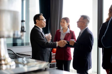 Başarılı Asyalı iş adamı, kutlama, anlaşma ve pazarlama ortaklığı, grup iş adamları ve başarı için kurumsal toplantı sırasında ortaklıkla el sıkışır..