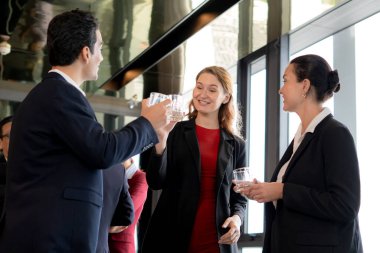 Grup iş adamları toplanıyor ve başarı için kutlama yapıyorlar ve ofiste içkiyle tezahürat yapıyorlar, modern ofiste işbirliği ve takım çalışması, iletişim ve pazarlama ile iletişim.