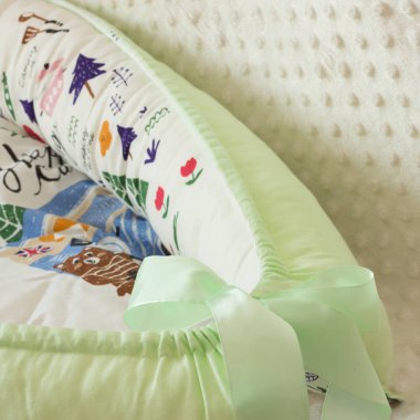 Yeni doğanlar için tekstil beyaz arka plandaki fotoğraf stüdyosunda, bebek yatağında yastığın yan tarafında, battaniyeler yürüyüş için zarflara, rahat ve güvenli bir uyku için bir kozaya dönüştürülür. 