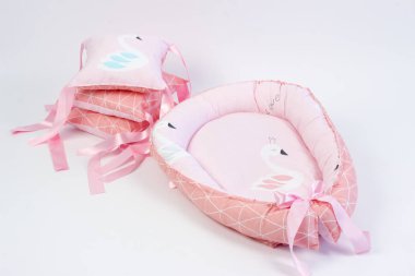 Yeni doğanlar için tekstil beyaz arka plandaki fotoğraf stüdyosunda, bebek yatağında yastığın yan tarafında, battaniyeler yürüyüş için zarflara, rahat ve güvenli bir uyku için bir kozaya dönüştürülür. 