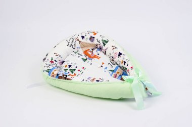 Yeni doğanlar için tekstil beyaz arka plandaki fotoğraf stüdyosunda, bebek yatağında yastığın yan tarafında, battaniyeler yürüyüş için zarflara, rahat ve güvenli bir uyku için bir kozaya dönüştürülür. 