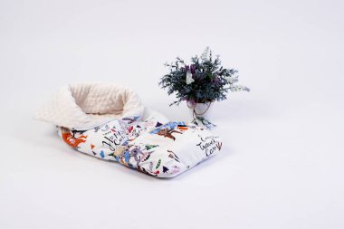 Yeni doğanlar için tekstil beyaz arka plandaki fotoğraf stüdyosunda, bebek yatağında yastığın yan tarafında, battaniyeler yürüyüş için zarflara, rahat ve güvenli bir uyku için bir kozaya dönüştürülür. 
