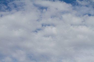 Arka plan beyaz bulutlu mavi bir gökyüzü.