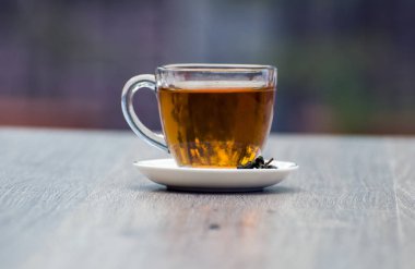 Gri ahşap zemin üzerine yeşil çay bardağı