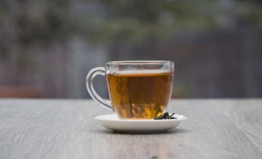 Gri ahşap zemin üzerine yeşil çay bardağı