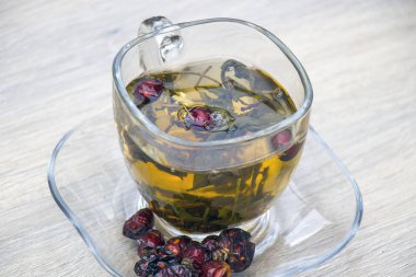 Gri ahşap zemin üzerine yeşil çay bardağı