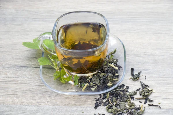 Gri ahşap zemin üzerine yeşil çay bardağı